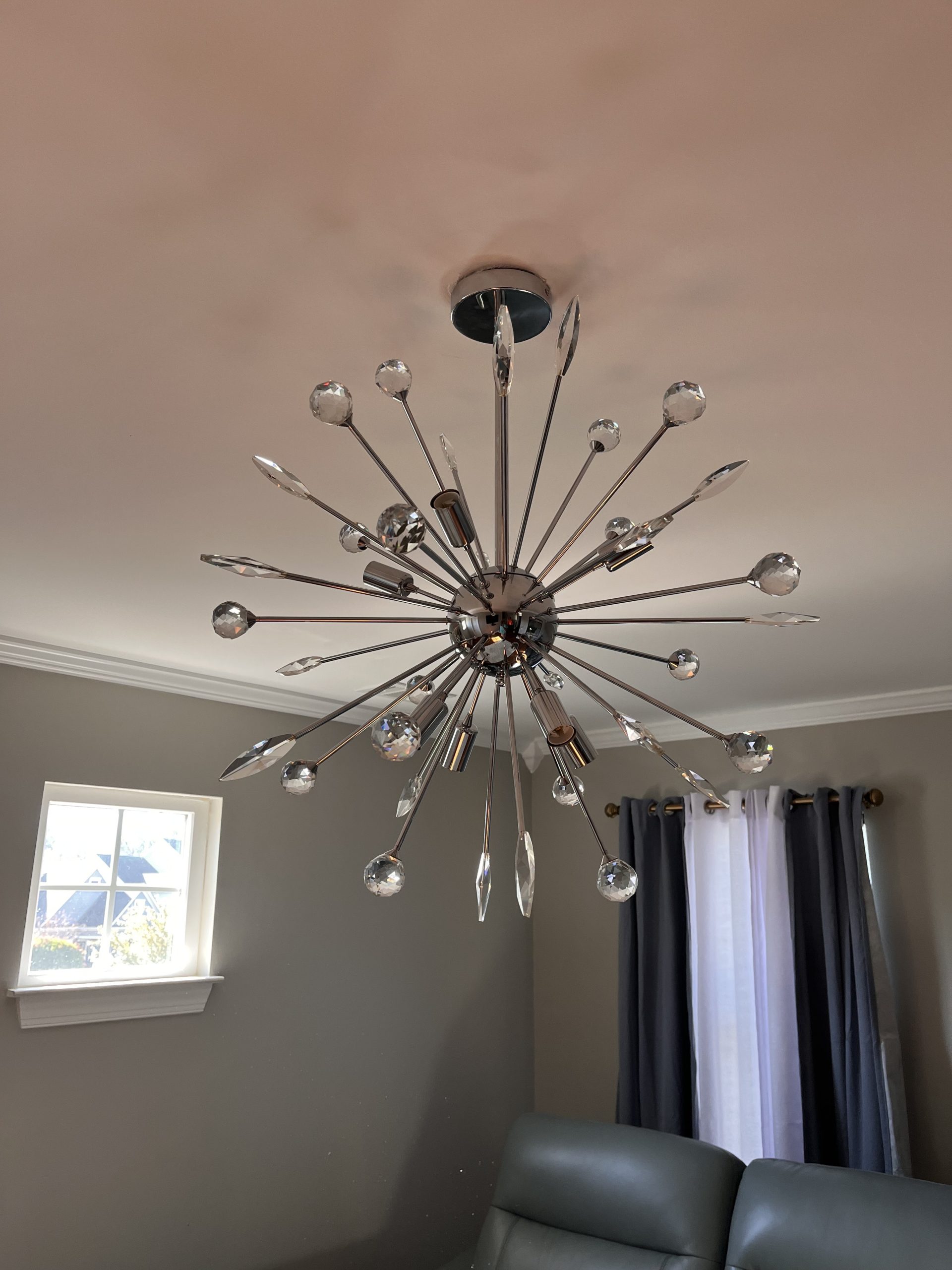 Chrome crystal sputnik chandelier installed on a living room ceiling