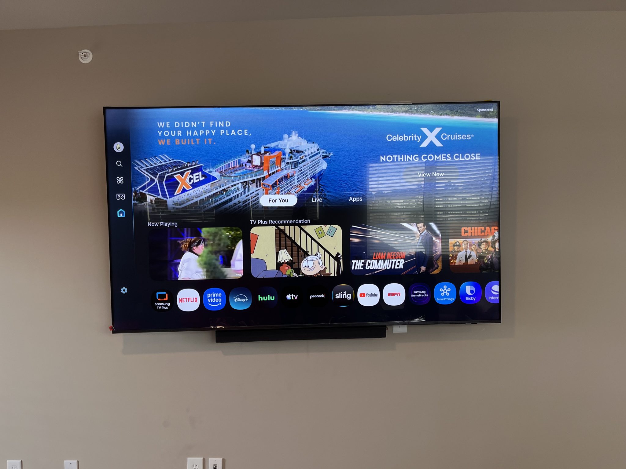 Samsung TV wall-mounted with a soundbar underneath in a living room