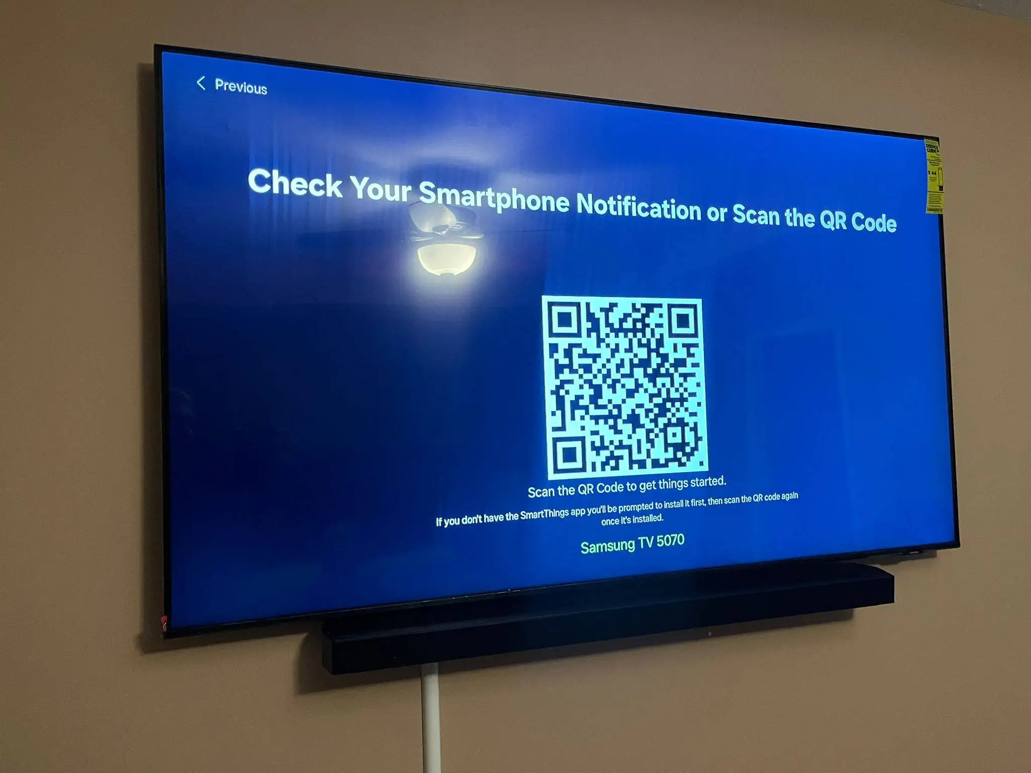Wall-mounted Samsung TV with a soundbar during first-time setup