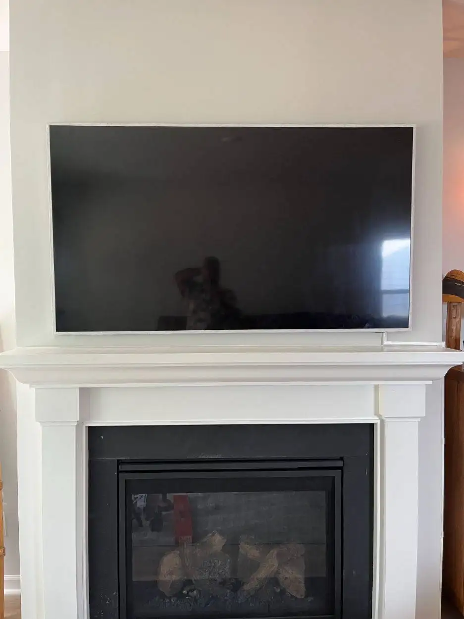 A wall-mounted TV positioned above the fireplace.