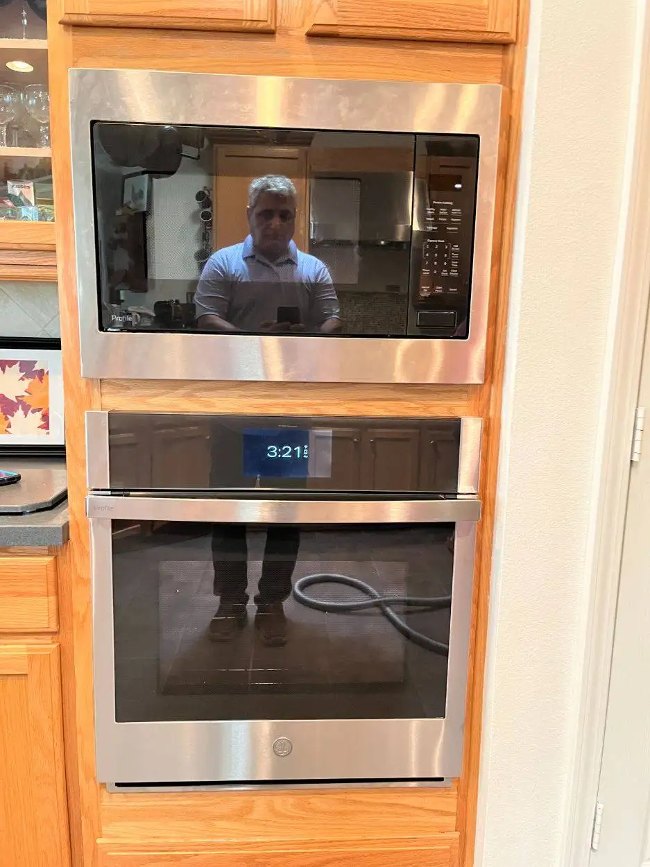 Stainless steel wall oven and microwave combo installed in oak cabinetry
