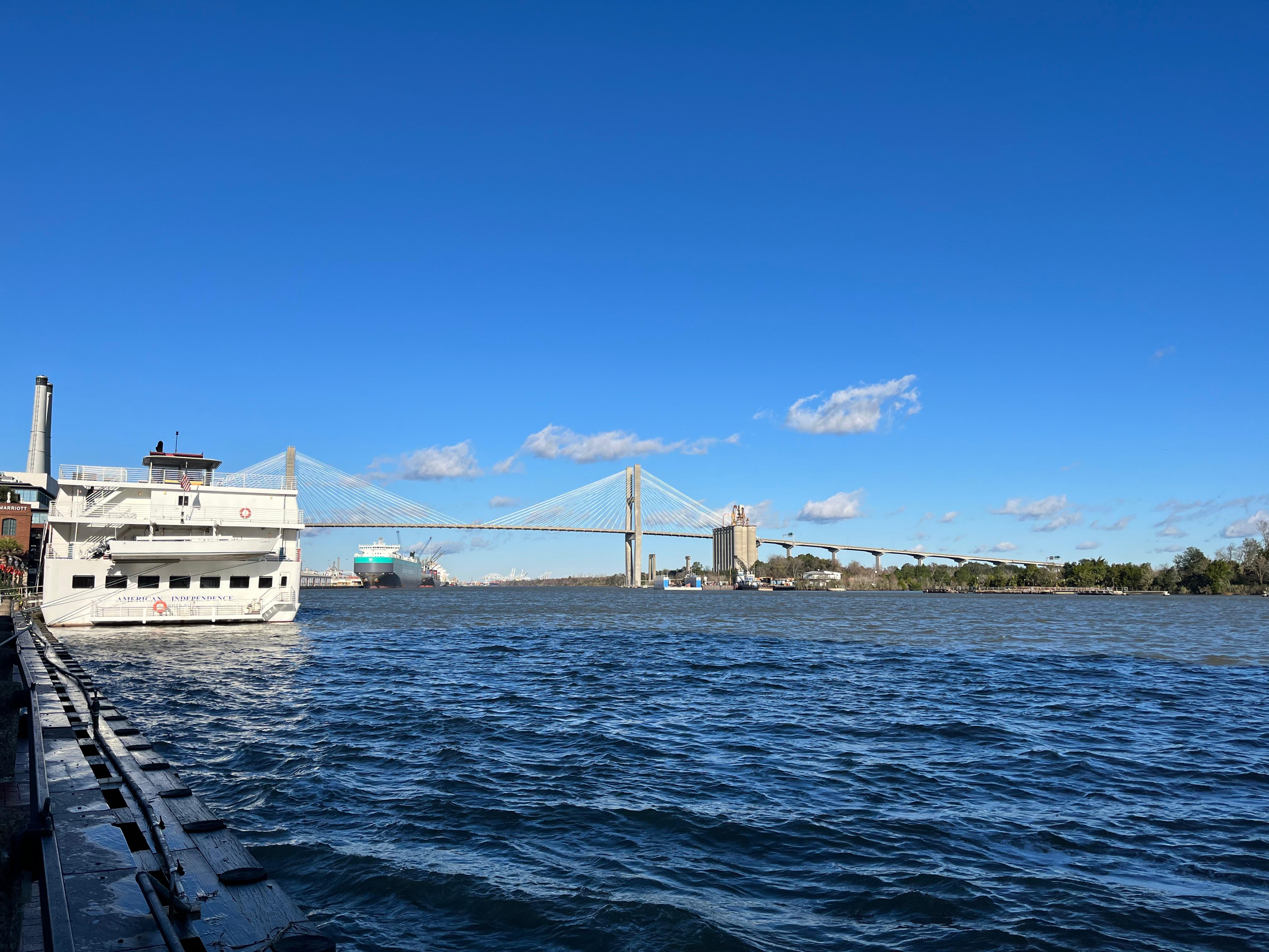 The Talmadge Memorial Bridge over the Savannah River with a riverboat docked in the foreground